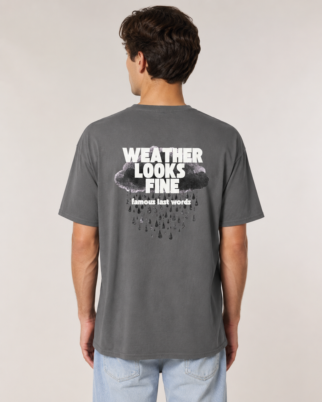 Person wearing a gray t-shirt with 'Weather Looks Fine' text on the back, standing against a plain background.